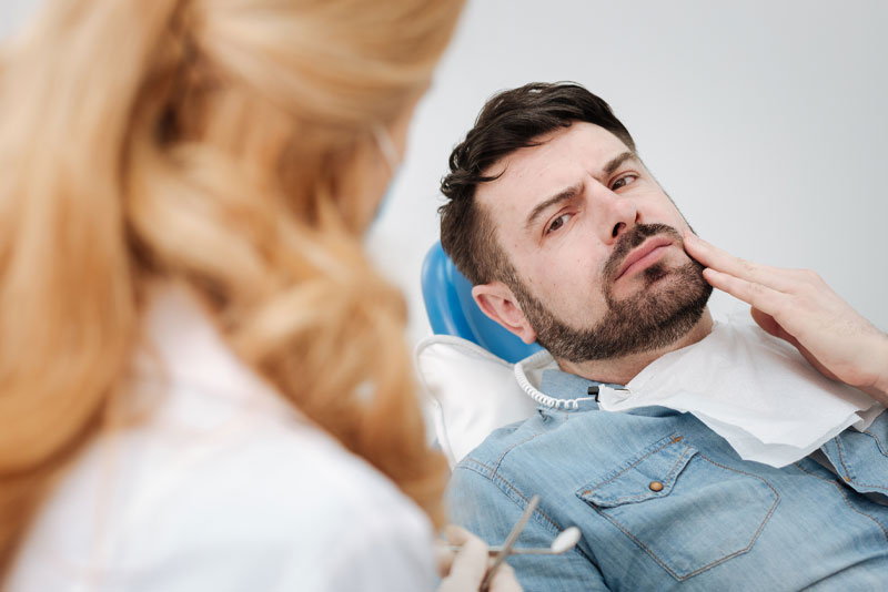 a dental patient frustrated by a painful impacted wisdom tooth